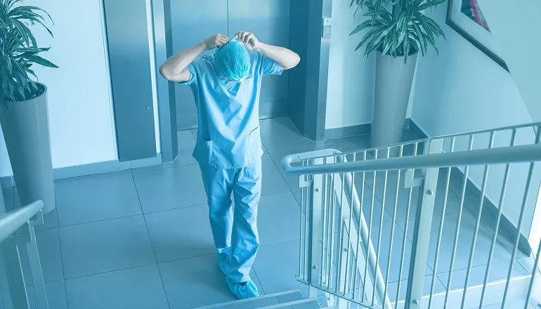 enfermero subiendo unas escaleras después de atender a una víctima por accidente de tráfico en un hospital público